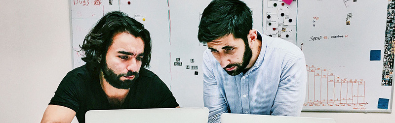 2 barbati se uite pe laptop