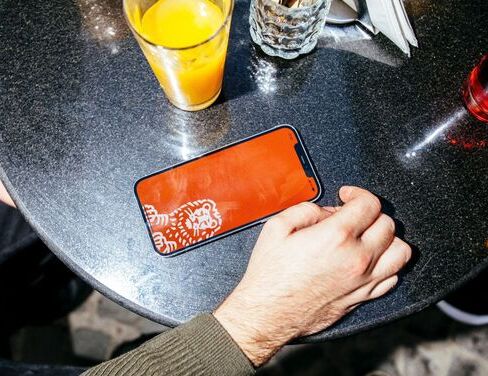 Mana pe masa langa un telefon si un pahar de suc